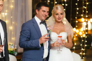 The bride and groom pose with wedding glasses The newlyweds are holding glasses