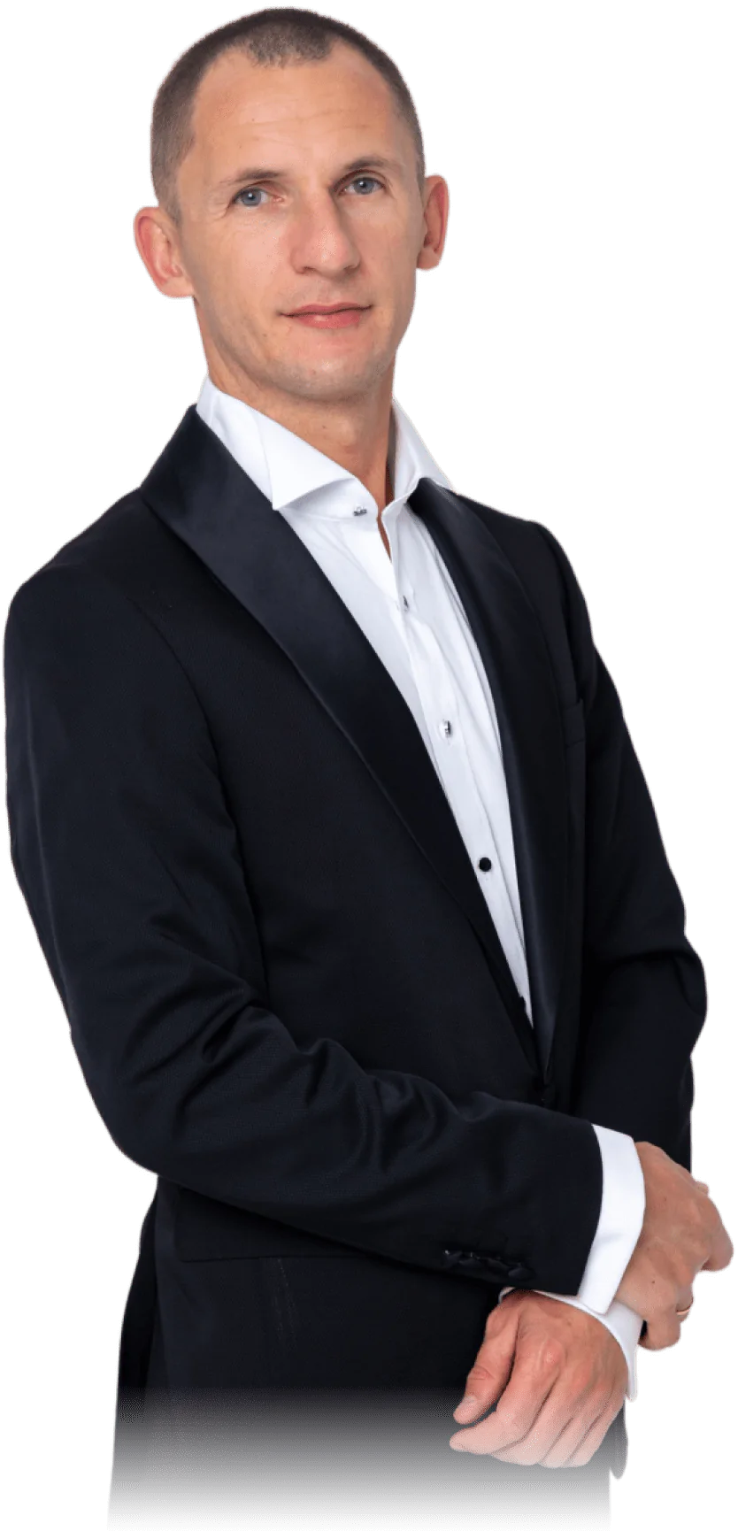 A man poses in a white shirt and black jacket A man in a shirt and jacket