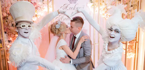 The newlyweds kiss, and the artists make a heart out of their hands for them Newlyweds kiss in the heart from the hands
