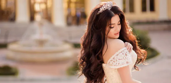 The bride in an off-the-shoulder dress poses in a tiara The bride in a tiara