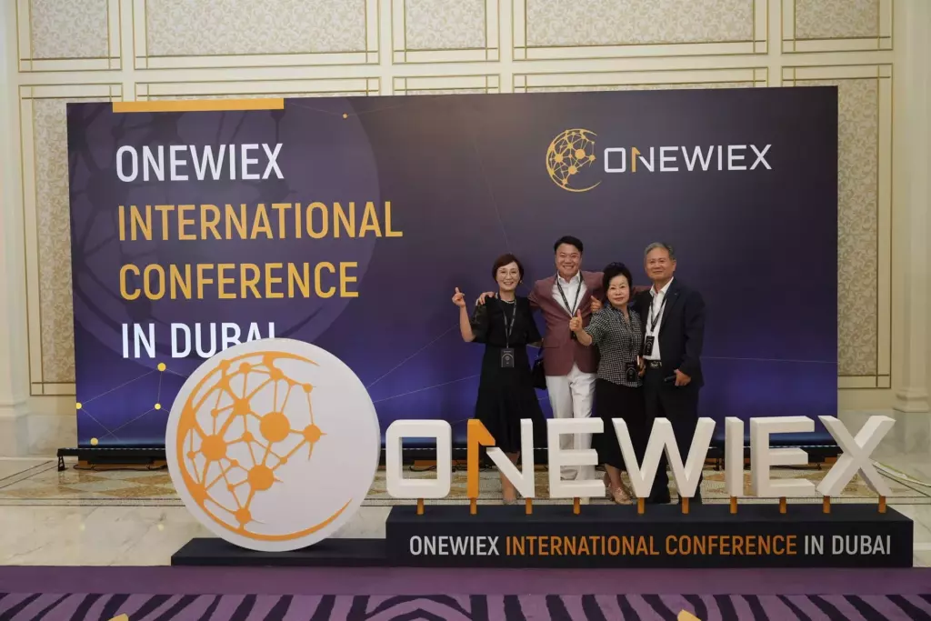 Participants pose in front of a large banner