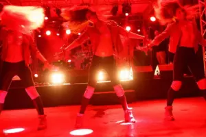 Three dancers in sparkling outfits