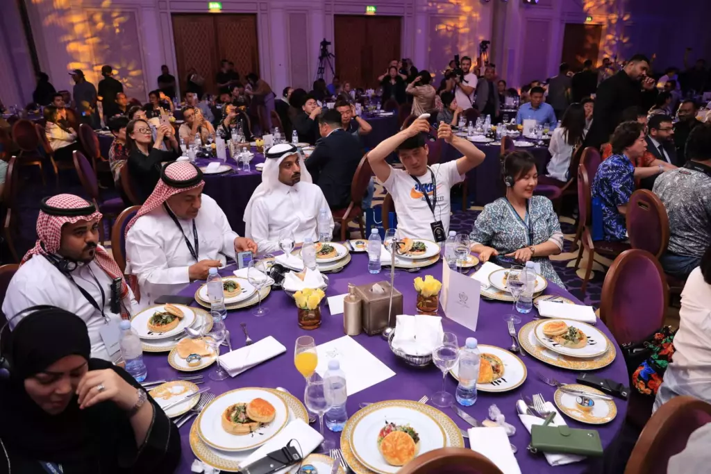 A lively dining event with guests seated at set tables The guests are sitting at the tables set