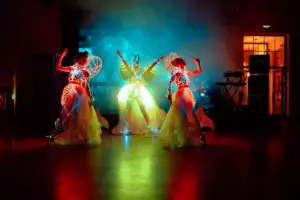 Three girls in glowing costumes