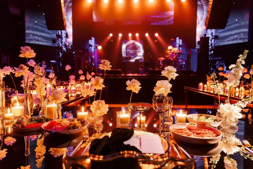 The festive table is decorated with burning candles in glasses and artificial flowers The festive table is decorated with flowers
