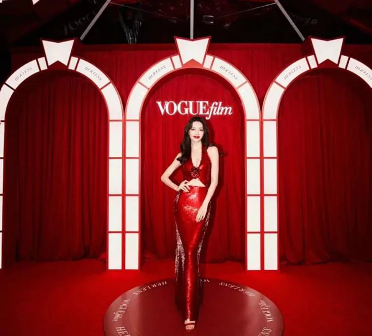 Woman in a bright red sequined dress against a matching red background Woman in a bright red sequined dress on a red background