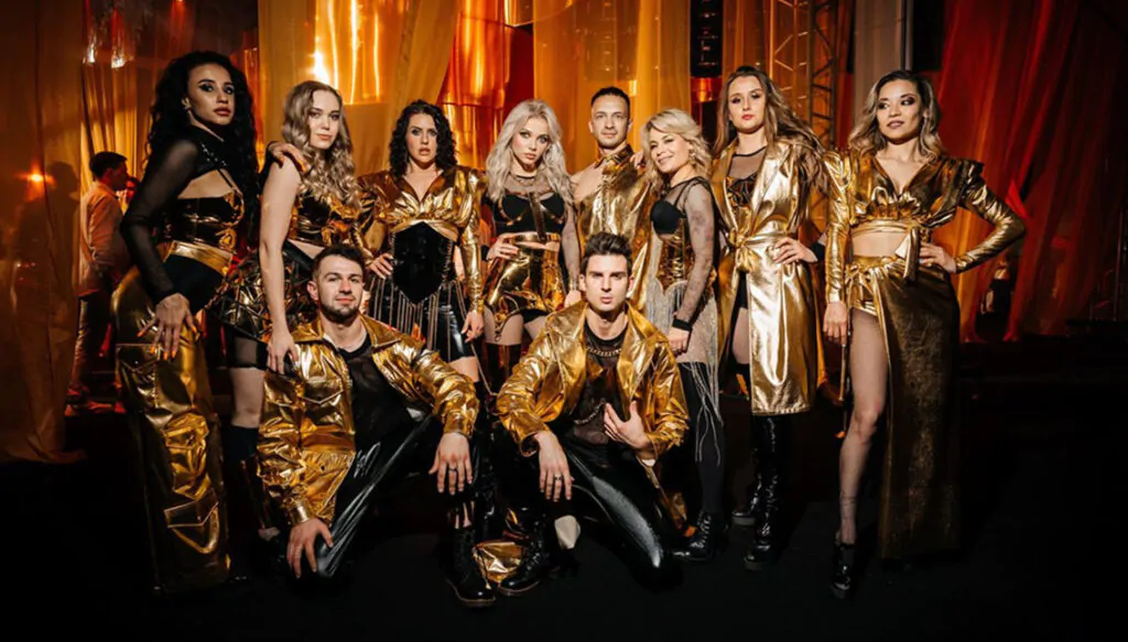 Group dressed in luxurious golden costumes posing together Group of people posing in golden costumes