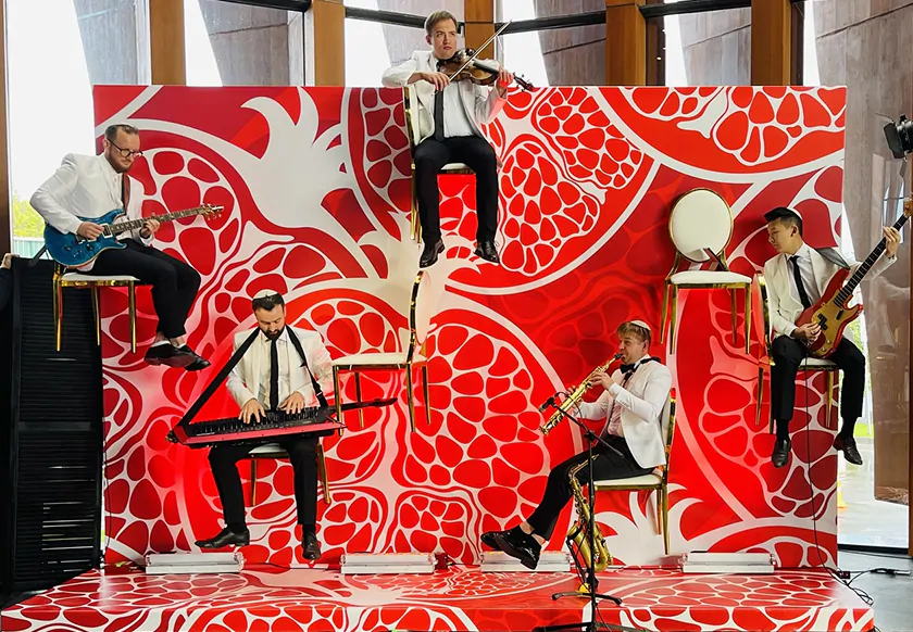 Musicians play on a red and white background
