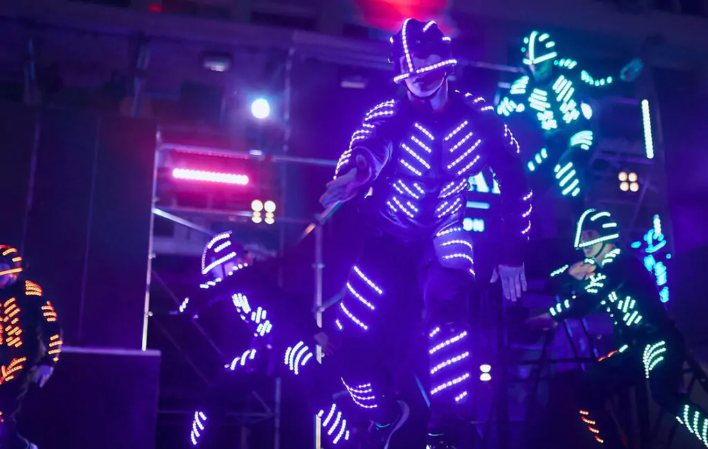 Group of dancers dressed in futuristic neon costumes Group of dancers in neon costumes
