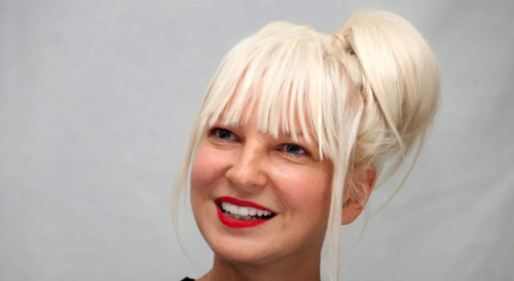 Sia under bright stage lights Smiling singer Sia