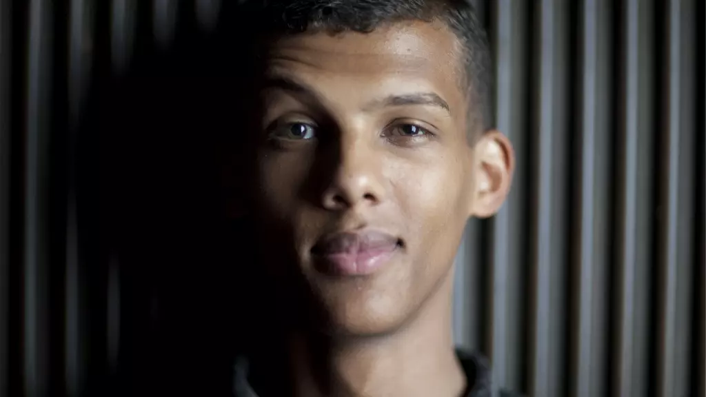 Stromae poses on a black background Stromae